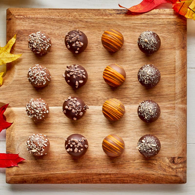 Sixteen Bissinger's autumn pie truffles on a wooden board