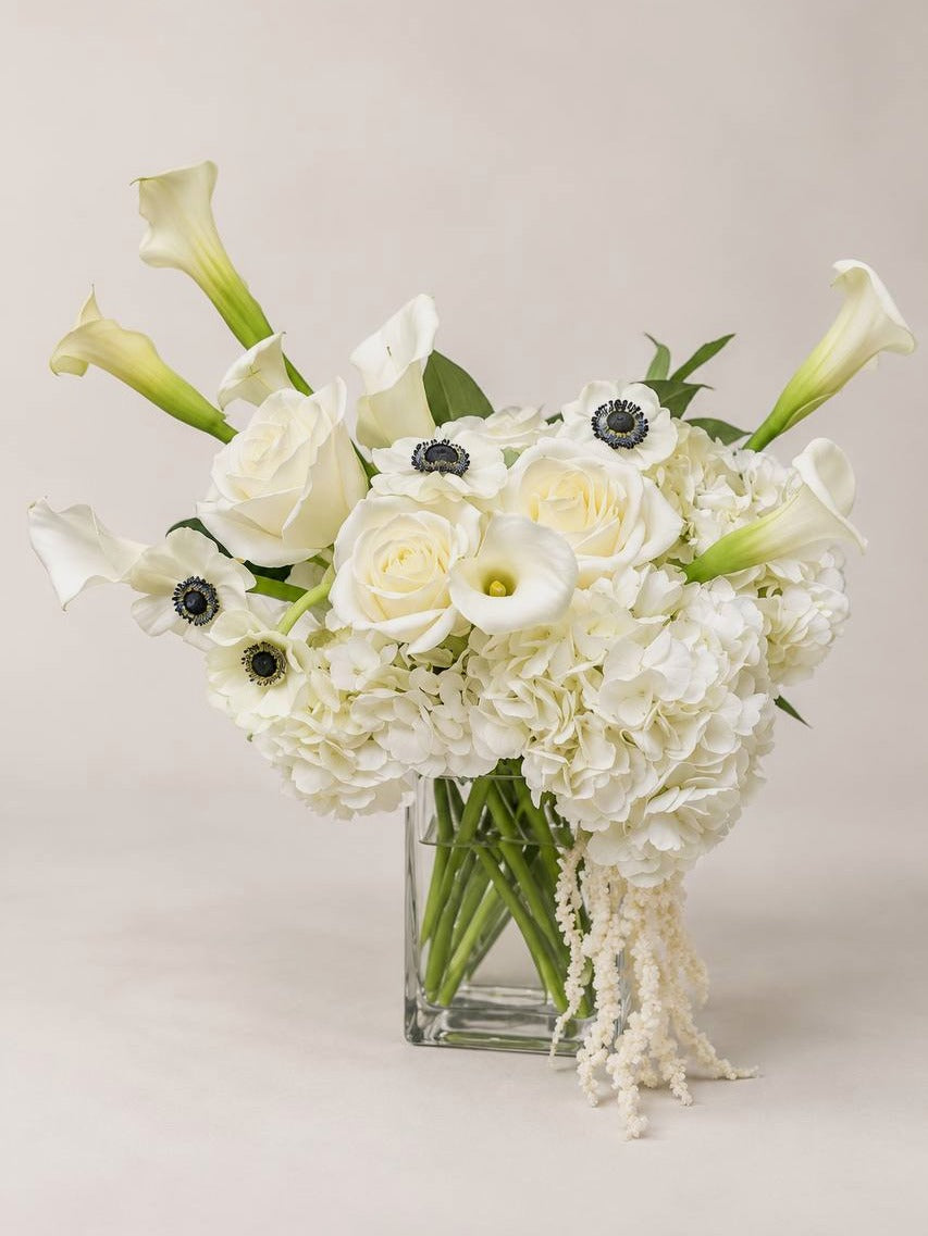 Calla Noir medium: white calla lily and anemone arrangement in a glass vase for a dining table