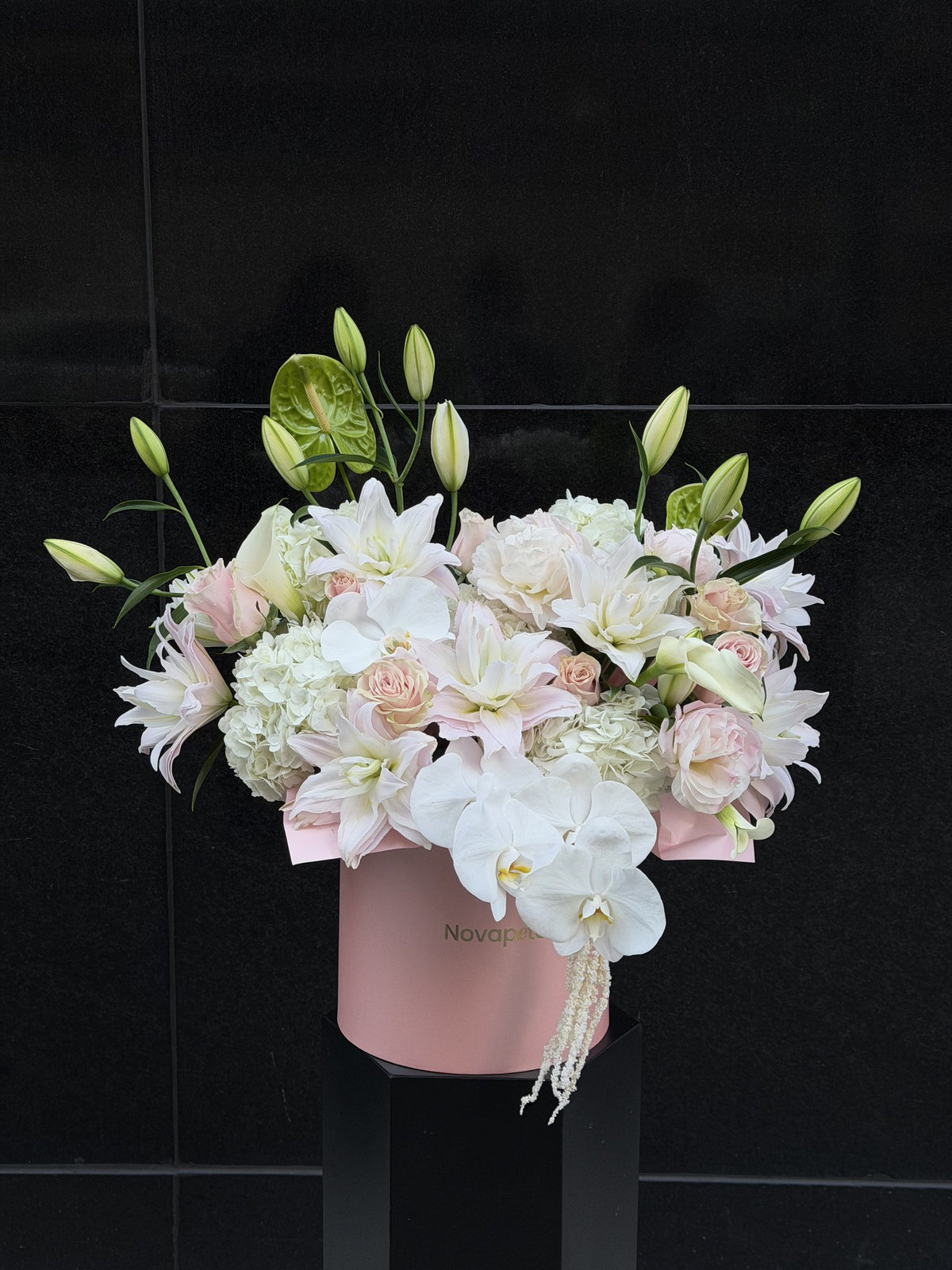 Chloe hat box arrangement with white and blush double lilies, white orchids, hydrangea and roses in a pink Novapetal box
