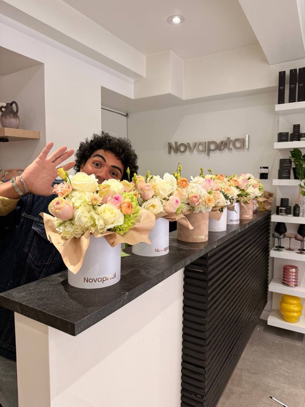 A Novapetal florist at the counter with a row of signature hat box arrangements in the Upper East Side studio