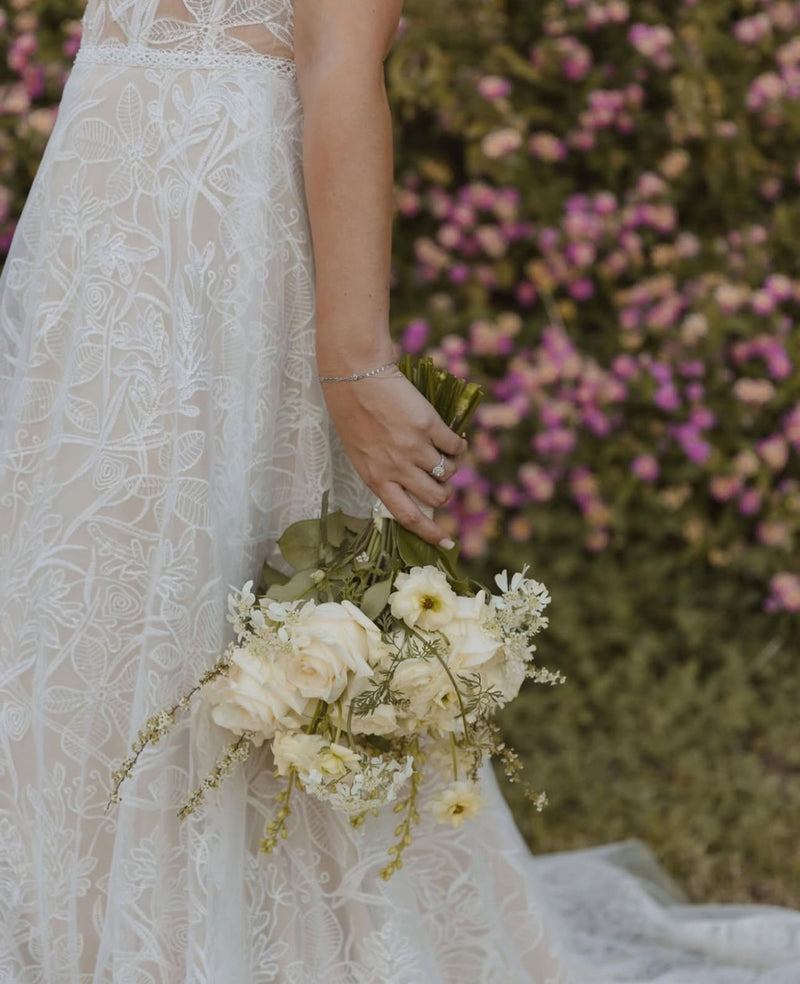 Bride holding a white and butter-yellow garden-flower bouquet