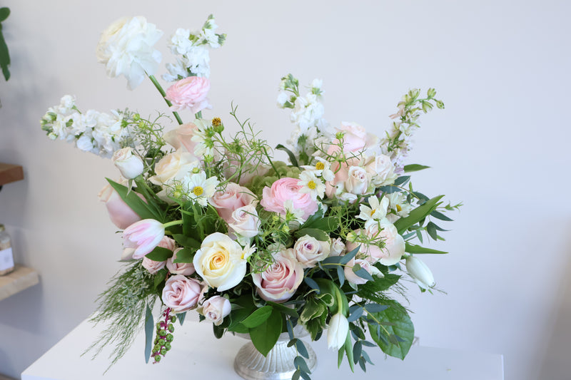 Blush and cream garden arrangement of roses stock and tulips in a footed vase