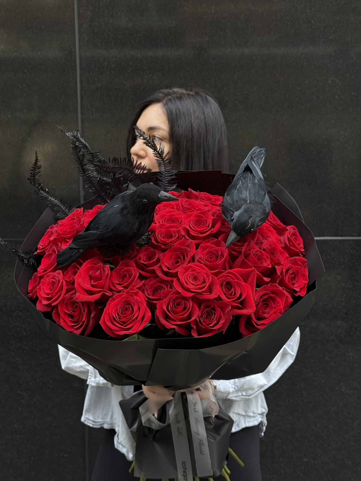 Bouquet of deep red roses with black ferns and two black ravens, wrapped in matte black paper