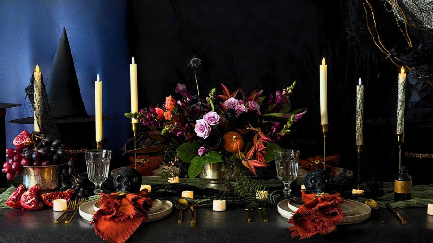 Plum and orange centerpiece with black taper candles, pumpkins and rust napkins