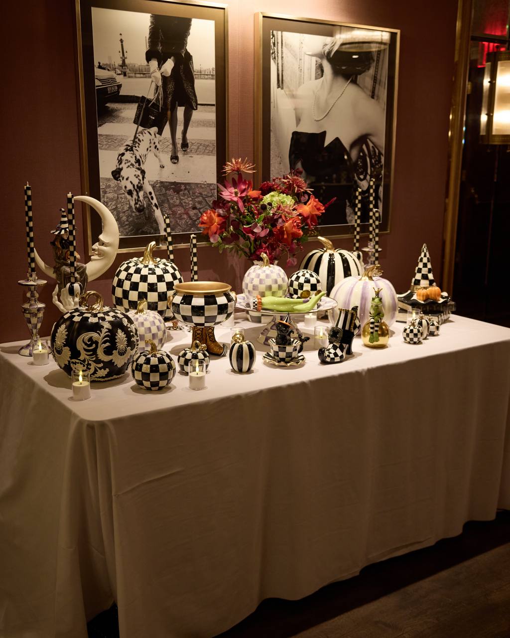 Display table styled with red and plum florals, checked pumpkins and taper candles at a home decor collaboration launch in New York