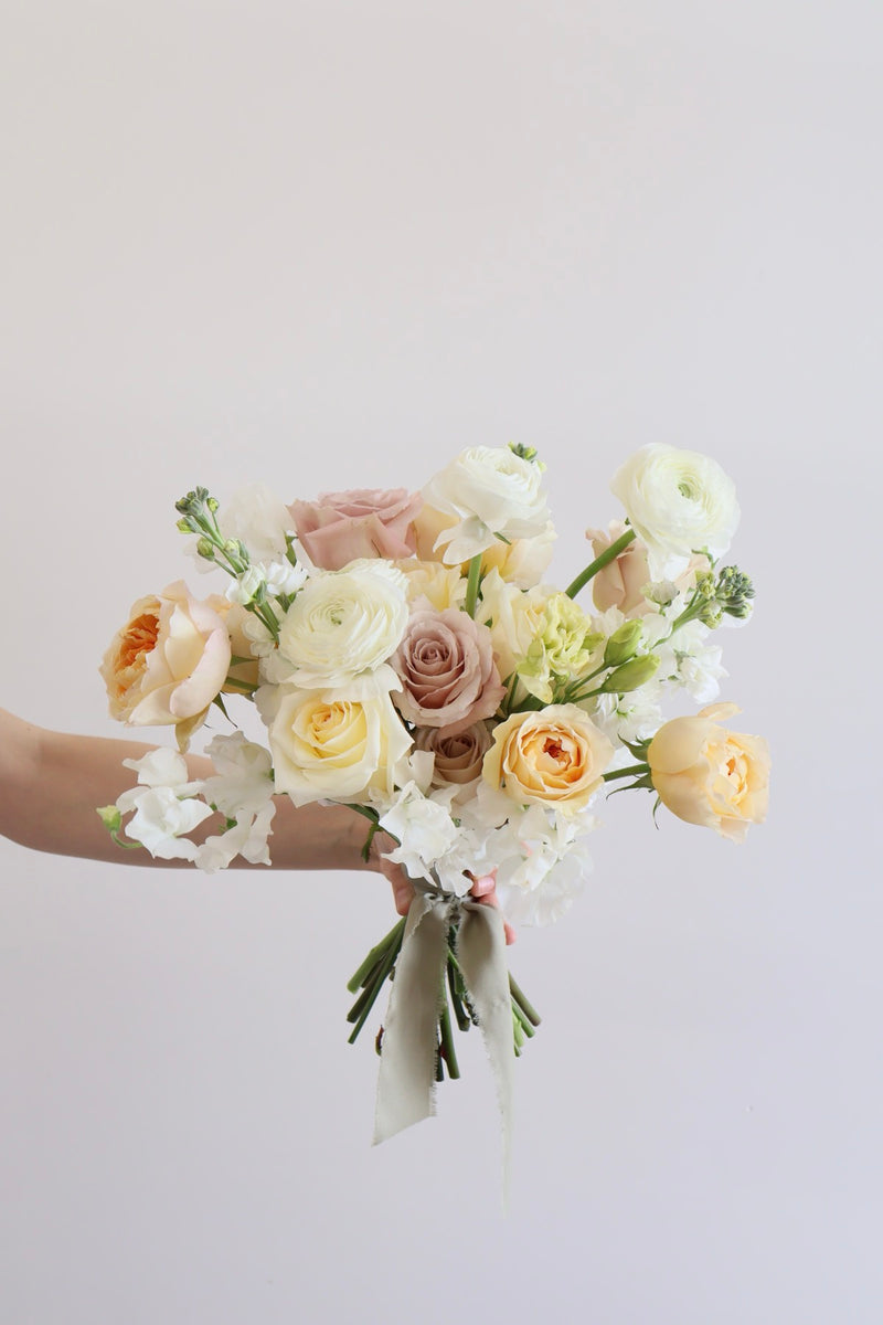 Cream peach and mauve rose bouquet with ranunculus and stock