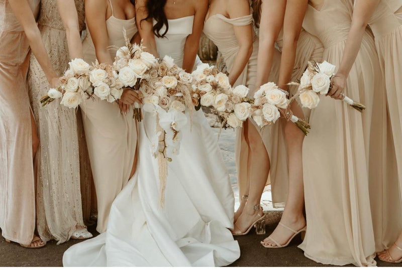 Bride and her bridesmaids holding cream rose and pampas bouquets